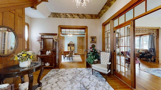 foyer featuring hardwood / wood-style floors, a chandelier, and french doors