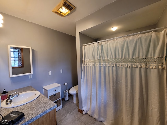 bathroom featuring tile floors, vanity, and toilet