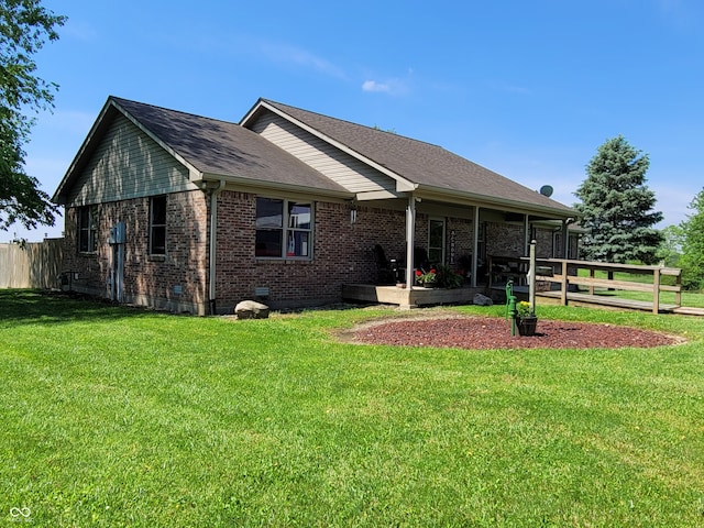 rear view of property featuring a yard