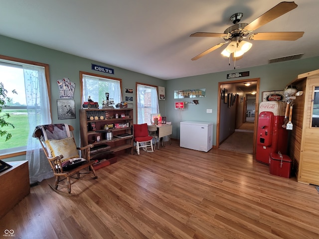 sitting room featuring ceiling fan and wood-type flooring