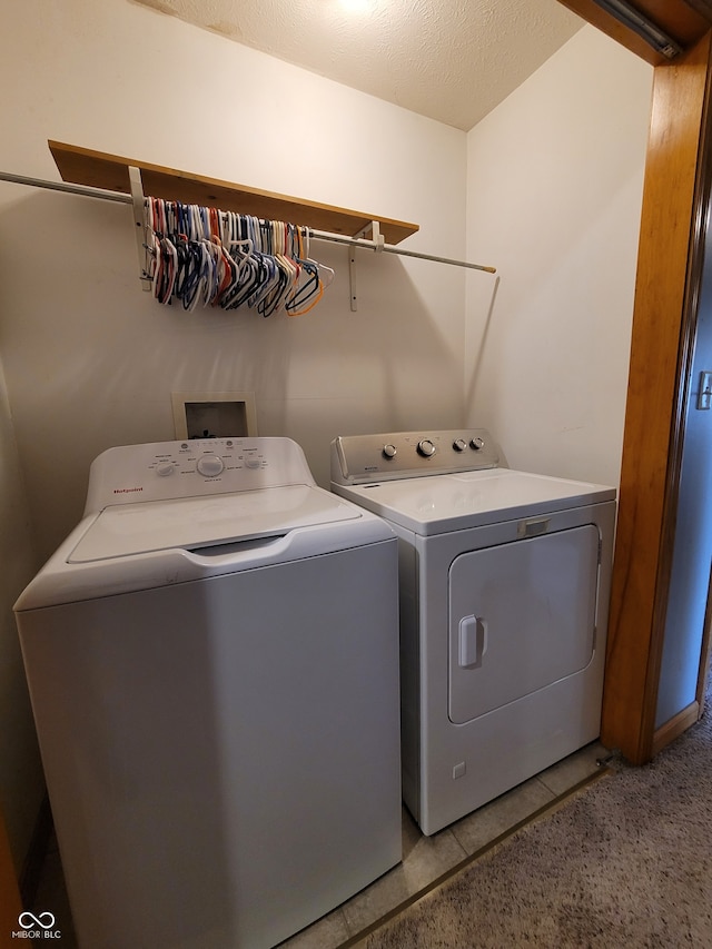 washroom featuring separate washer and dryer, tile flooring, hookup for a washing machine, and a textured ceiling