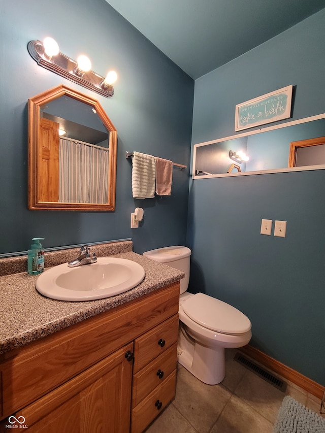 bathroom with tile flooring, vanity, and toilet