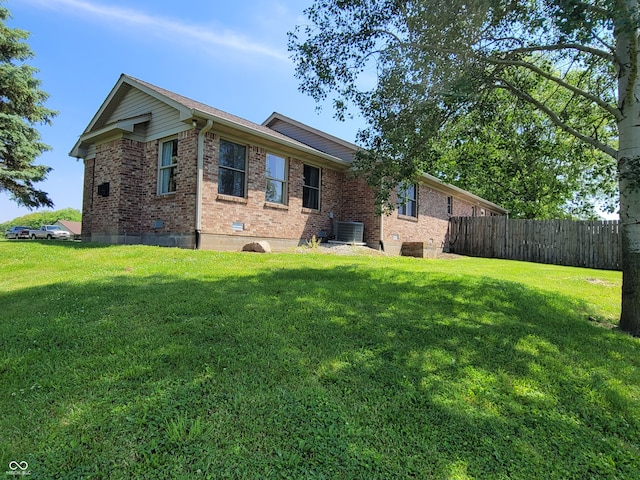 exterior space with central AC and a lawn