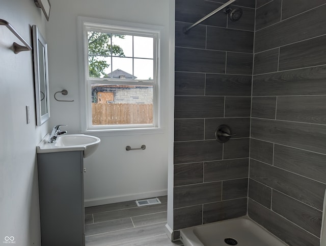 bathroom featuring a tile shower and vanity