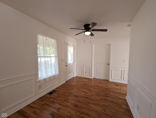 unfurnished room with dark hardwood / wood-style flooring and ceiling fan