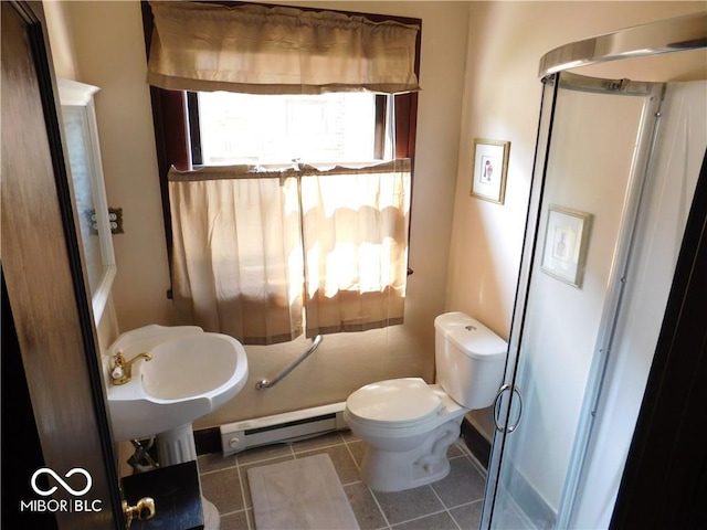 bathroom featuring tile flooring, baseboard heating, and toilet