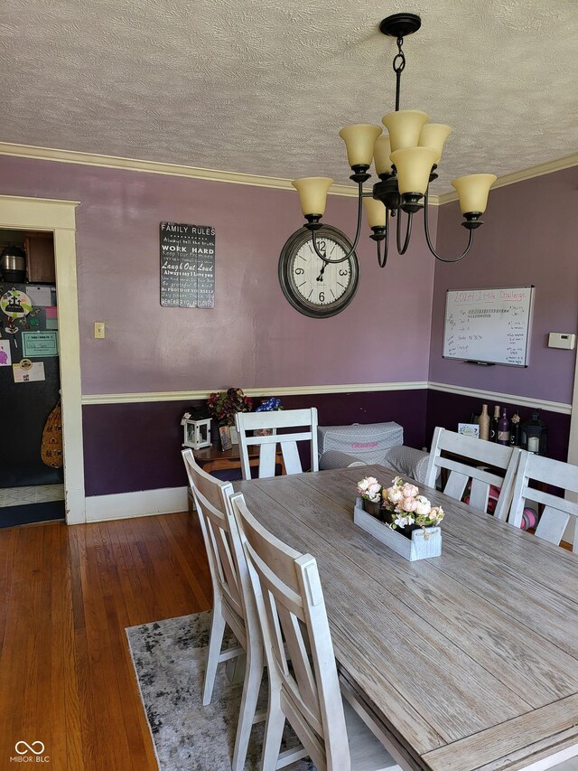 715 5th St, Covington, IN 47932 - dining room with a textured ceiling, ornamental molding, an inviting chandelier, and hardwood / wood-style flooring