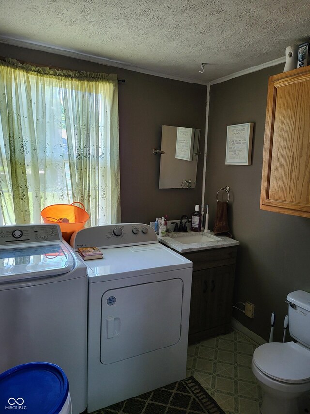 715 5th St, Covington, IN 47932 - laundry area with washing machine and clothes dryer, a textured ceiling, crown molding, tile patterned floors, and a sink