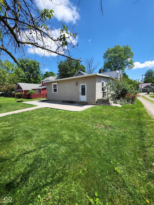 715 5th St, Covington, IN 47932 - rear view of house with a lawn, a chimney, and a patio area