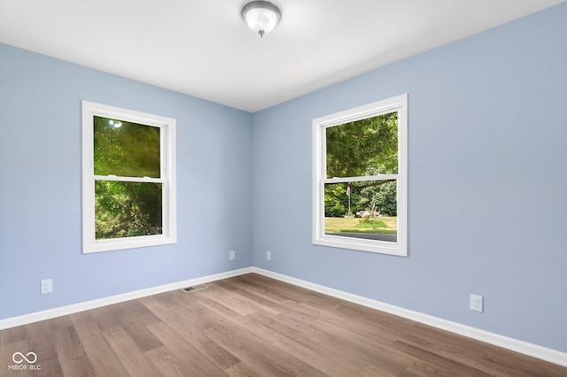 empty room with baseboards and wood finished floors