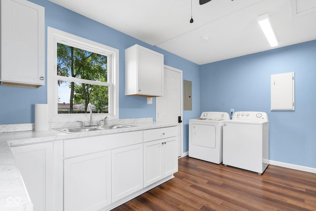 clothes washing area featuring a sink, electric panel, cabinet space, dark wood-style flooring, and washing machine and clothes dryer