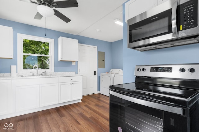 kitchen with dark wood-style floors, separate washer and dryer, a sink, ceiling fan, and stainless steel appliances