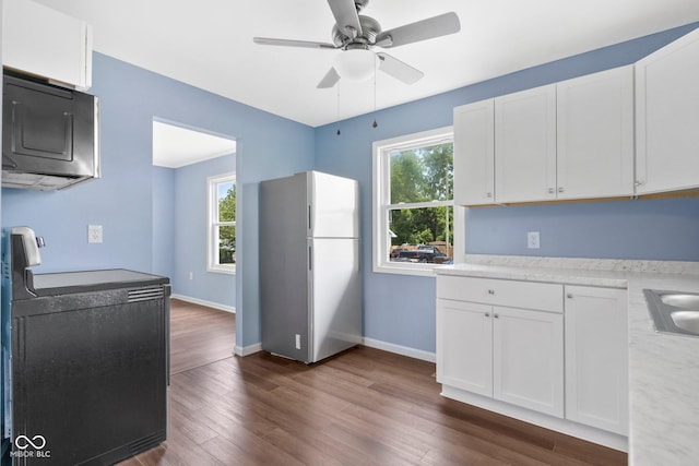 kitchen with a ceiling fan, dark wood-style floors, freestanding refrigerator, black / electric stove, and light countertops