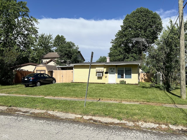 view of front of property featuring a front yard and cooling unit