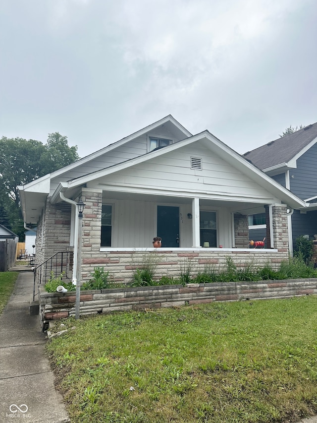 view of front of house with a porch and a front lawn