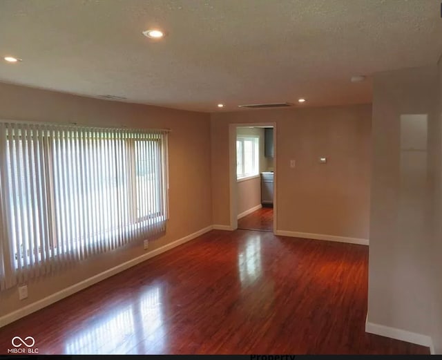 unfurnished room featuring a textured ceiling and wood-type flooring