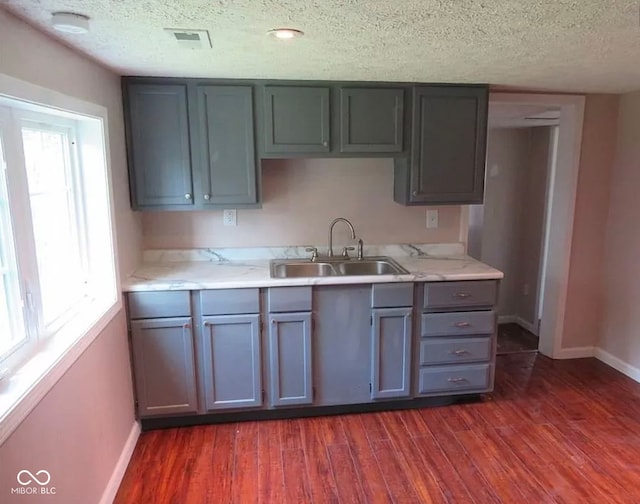 kitchen with sink, dark hardwood / wood-style flooring, and a textured ceiling