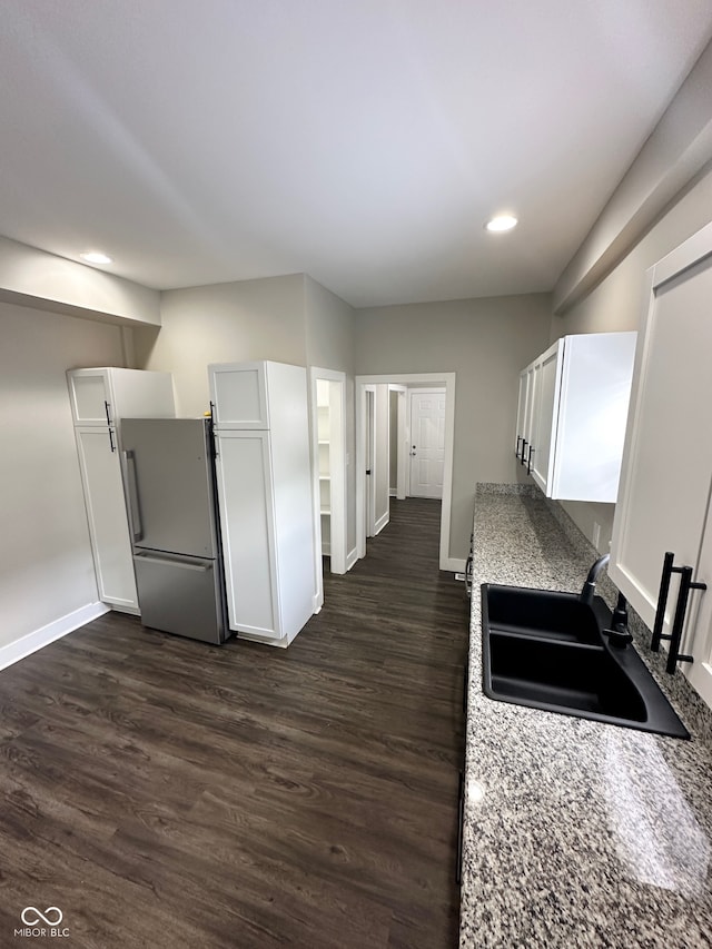 kitchen featuring white cabinets, sink, dark wood-type flooring, and stainless steel fridge