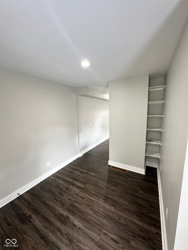 basement with dark hardwood / wood-style flooring