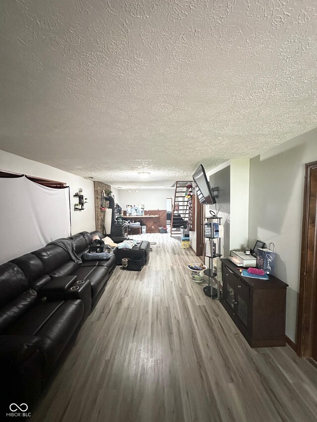 living room featuring a textured ceiling and wood-type flooring