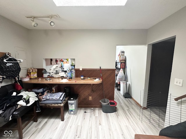 office with a skylight, wood finished floors, and track lighting