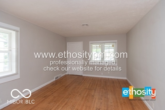 empty room with a textured ceiling and hardwood / wood-style floors