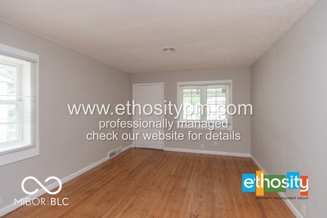 3521 N Riley Ave, Indianapolis, IN 46218 - spare room with wood finished floors, baseboards, and visible vents