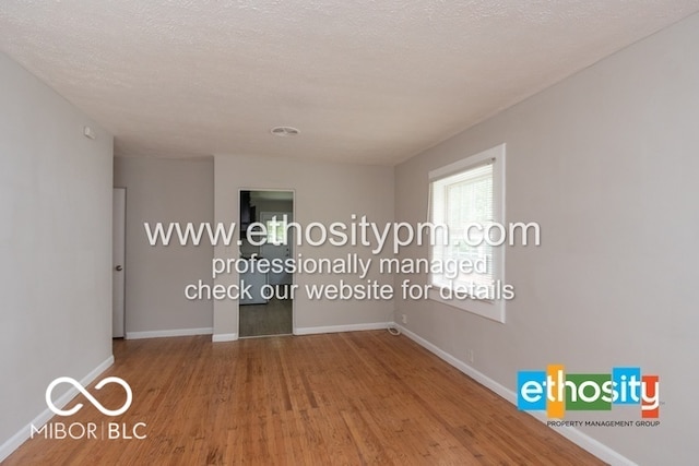 empty room featuring a textured ceiling and hardwood / wood-style floors