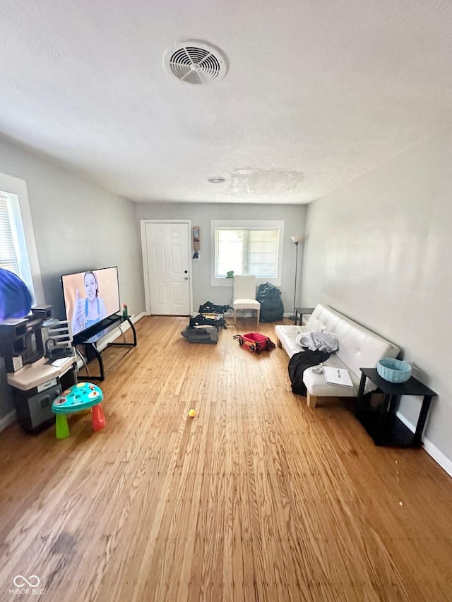 3521 N Riley Ave, Indianapolis, IN 46218 - living room featuring baseboards, visible vents, and wood finished floors
