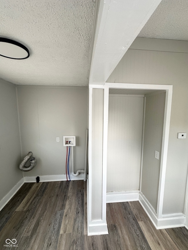 clothes washing area with dark hardwood / wood-style floors, hookup for a washing machine, and a textured ceiling