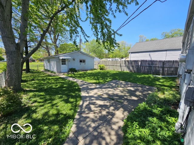 view of yard with an outdoor structure, a fenced backyard, and a patio