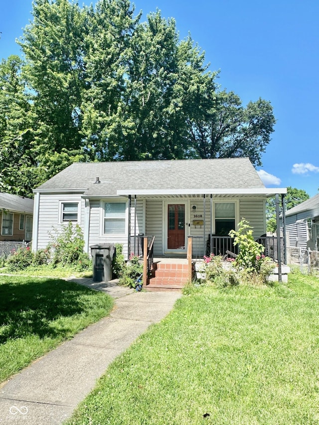 view of front facade featuring a front yard, a porch, and fence