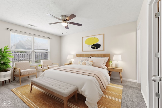 bedroom with ceiling fan, carpet floors, and a textured ceiling