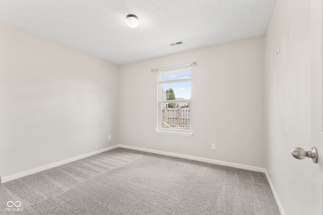 carpeted spare room featuring a textured ceiling