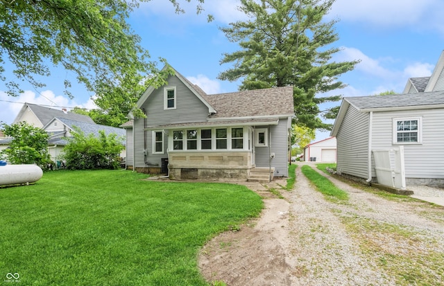 back of property featuring a lawn, an outbuilding, and a garage