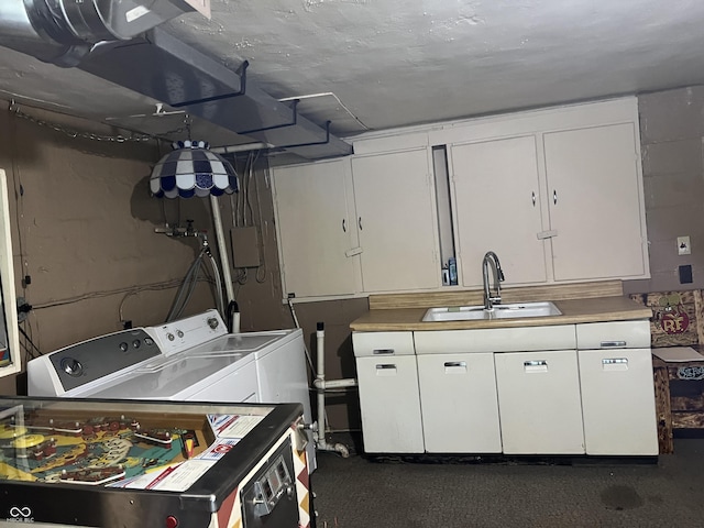 laundry area featuring cabinets, sink, and washer and clothes dryer