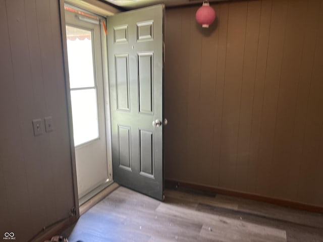 interior space with wooden walls and light hardwood / wood-style floors