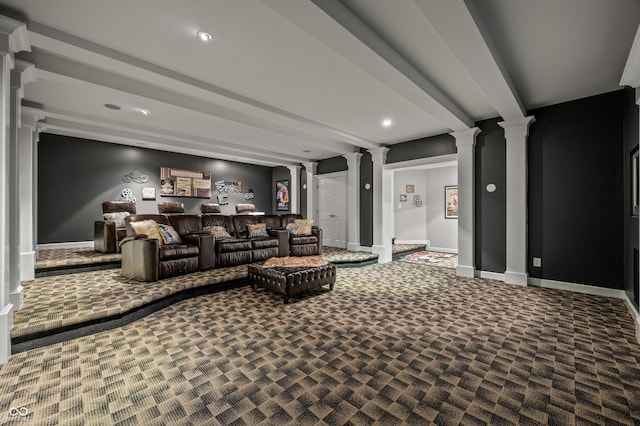 carpeted home theater room with beam ceiling