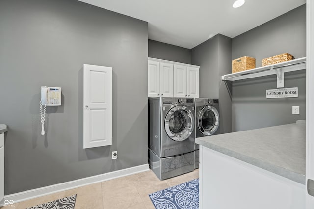 laundry area with cabinets, light tile patterned floors, and washer and clothes dryer