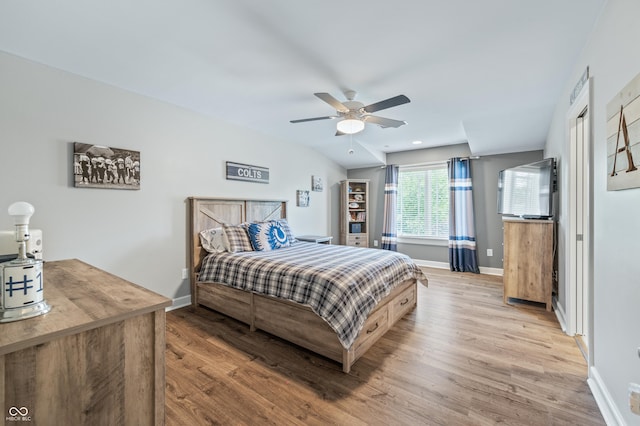 bedroom with vaulted ceiling, light hardwood / wood-style flooring, and ceiling fan