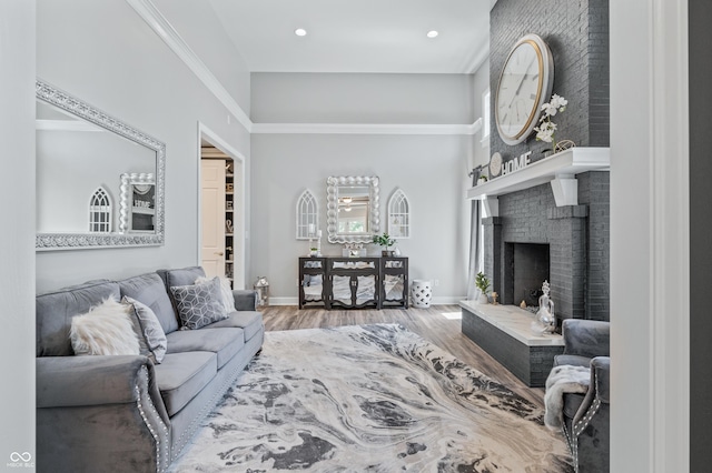 living room with hardwood / wood-style floors, a brick fireplace, and ornamental molding