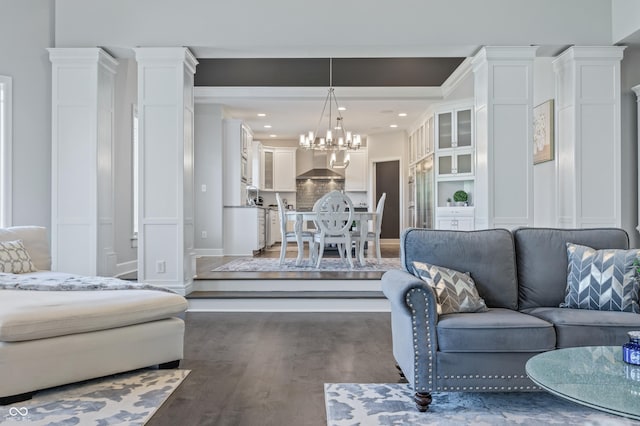 living room with dark wood-type flooring and an inviting chandelier