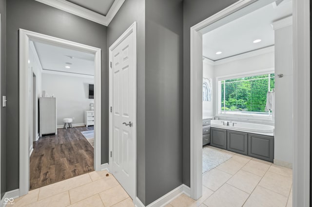 hallway with light hardwood / wood-style floors and crown molding