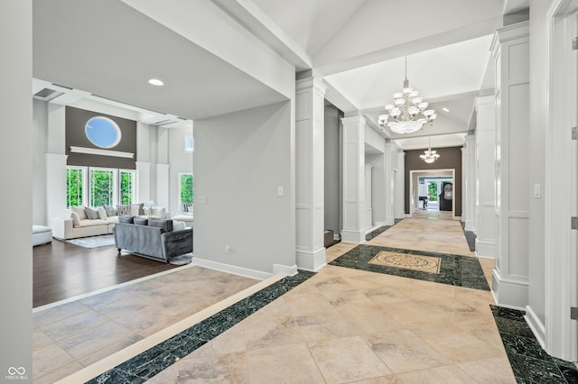 corridor with decorative columns and a notable chandelier