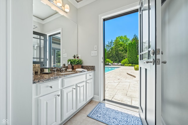 interior space with tile patterned floors, plenty of natural light, vanity, and ornamental molding