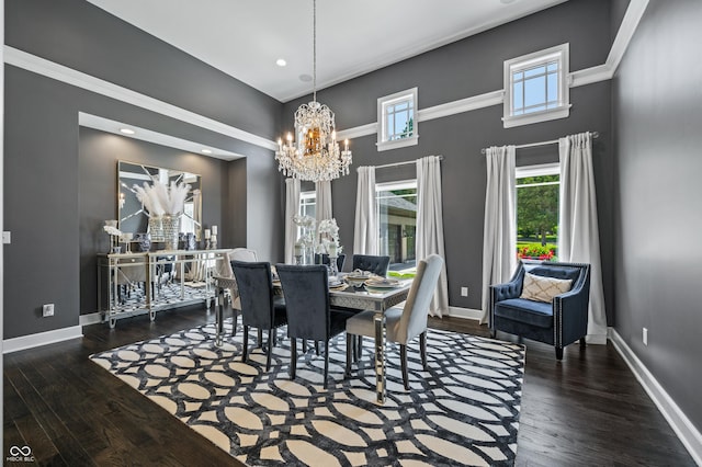 dining area with crown molding, dark hardwood / wood-style flooring, a chandelier, and a high ceiling