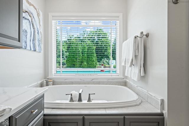 bathroom featuring a tub to relax in, plenty of natural light, and vanity