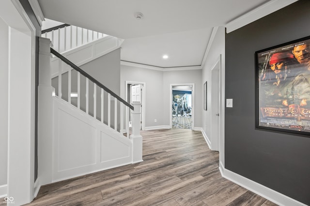 foyer with crown molding and wood-type flooring