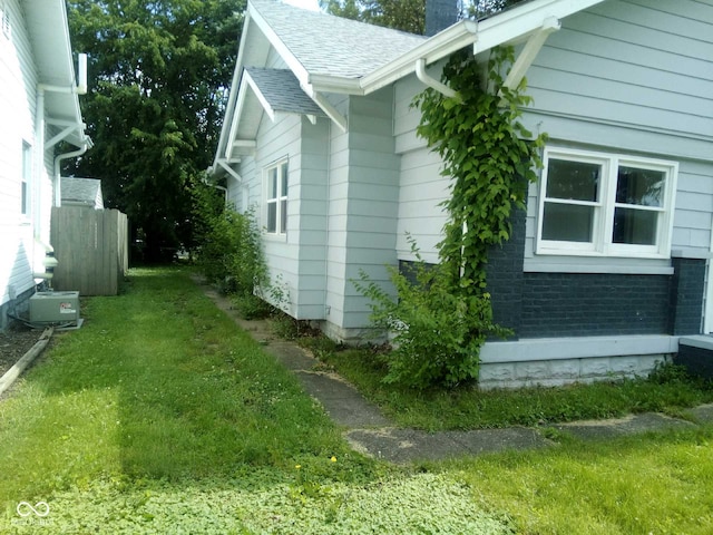 view of side of home with a yard and central air condition unit