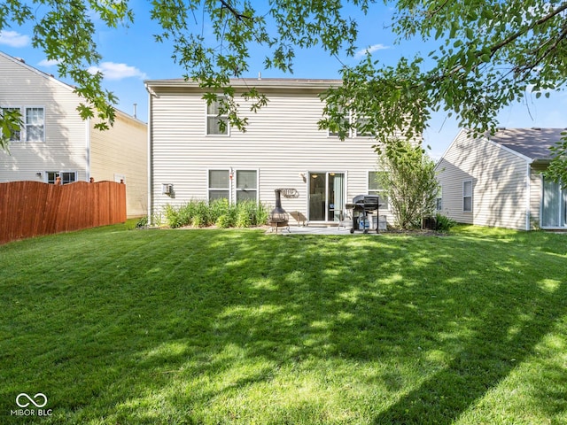 back of house featuring a lawn and a patio area